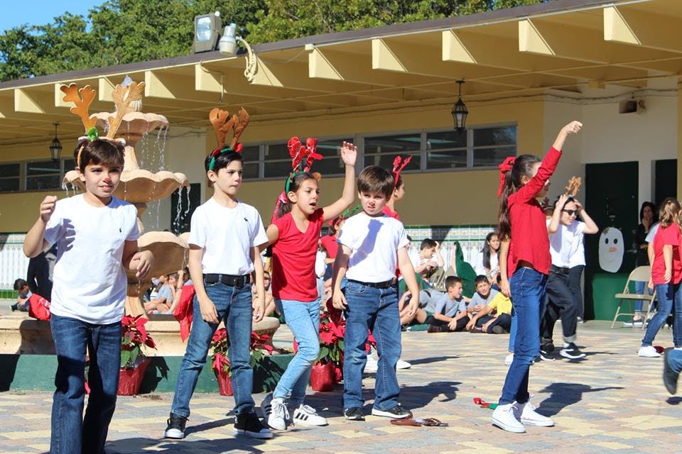 Children in holiday headbands performing outdoors