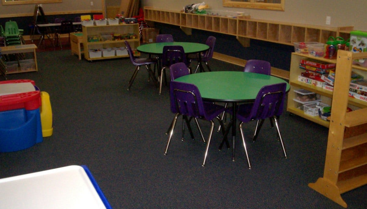 Classroom with small green tables and purple chairs