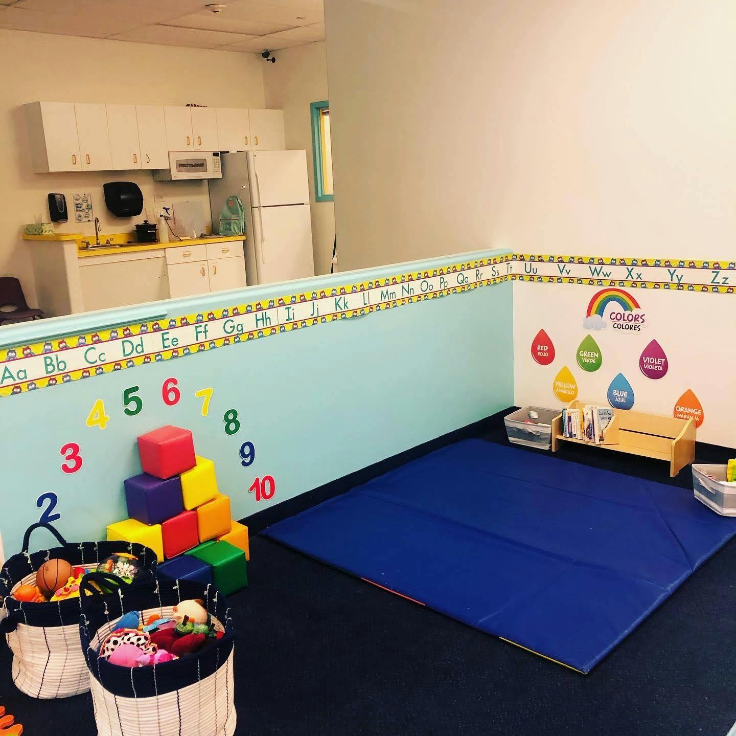 Playroom with alphabet and number decorations, colorful blocks, and a blue mat