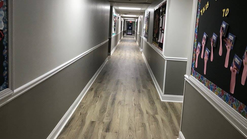 Long hallway with wood floor and bulletin boards