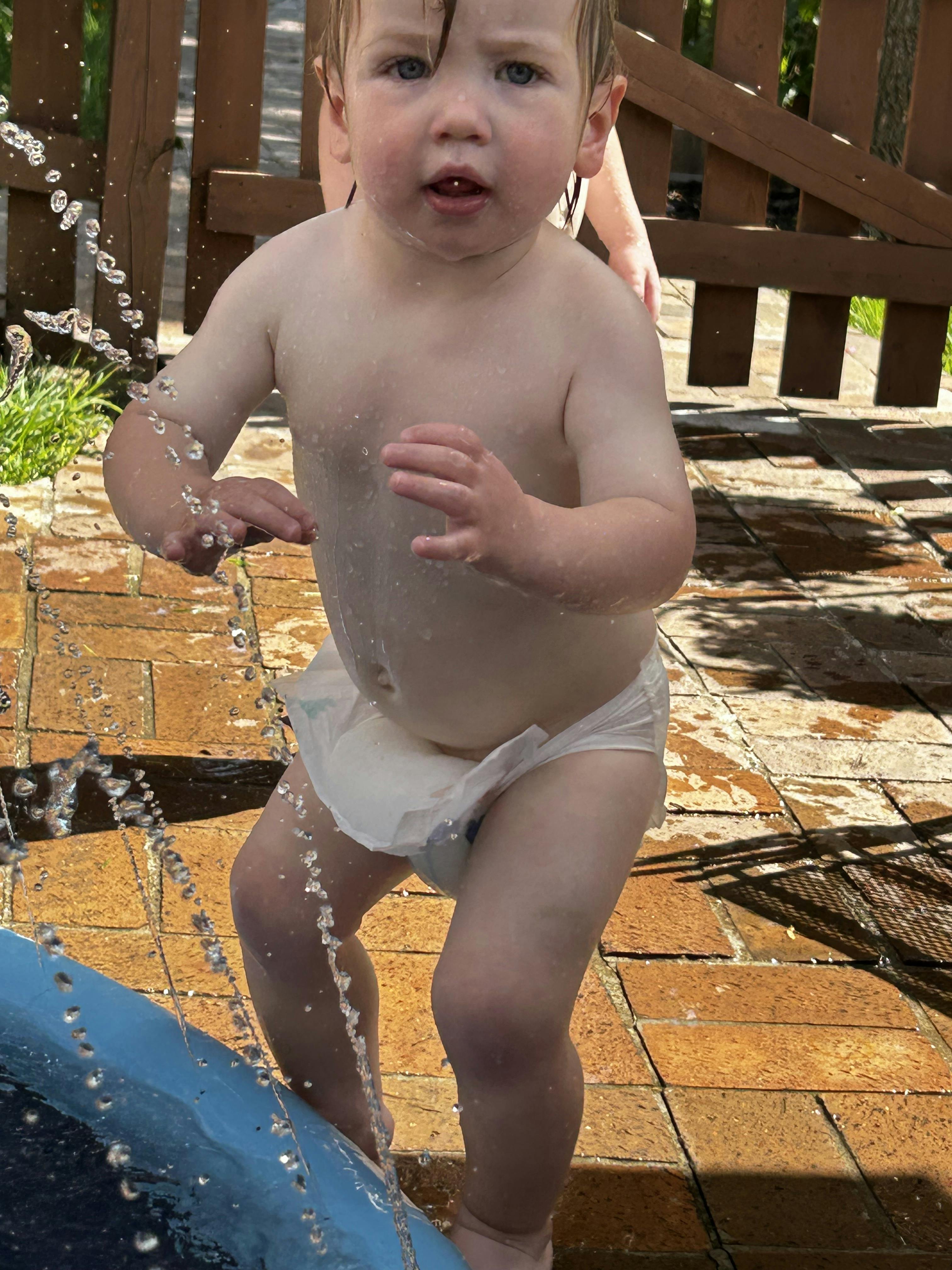 Child in a diaper playing in water