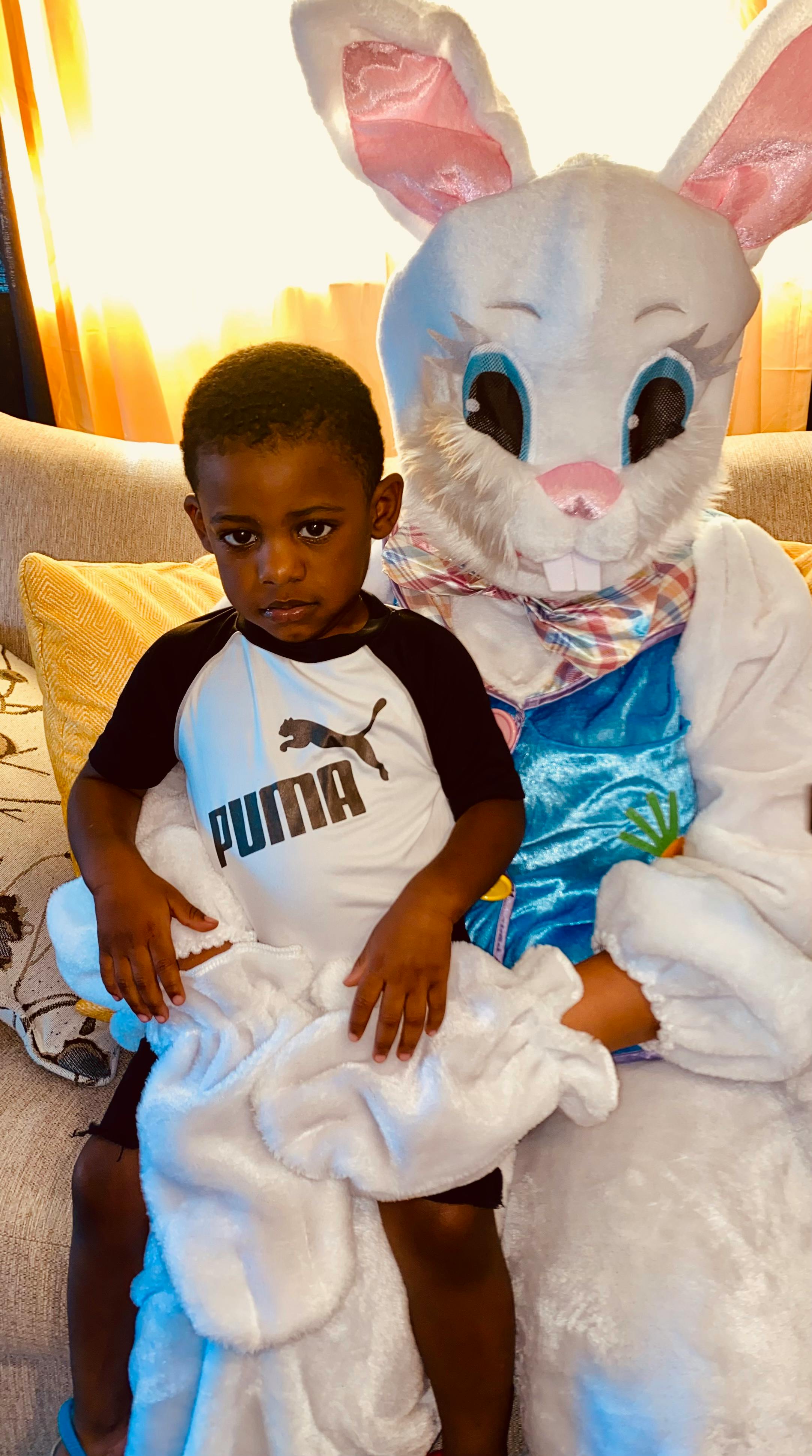 Child sitting on the lap of a person in a bunny costume