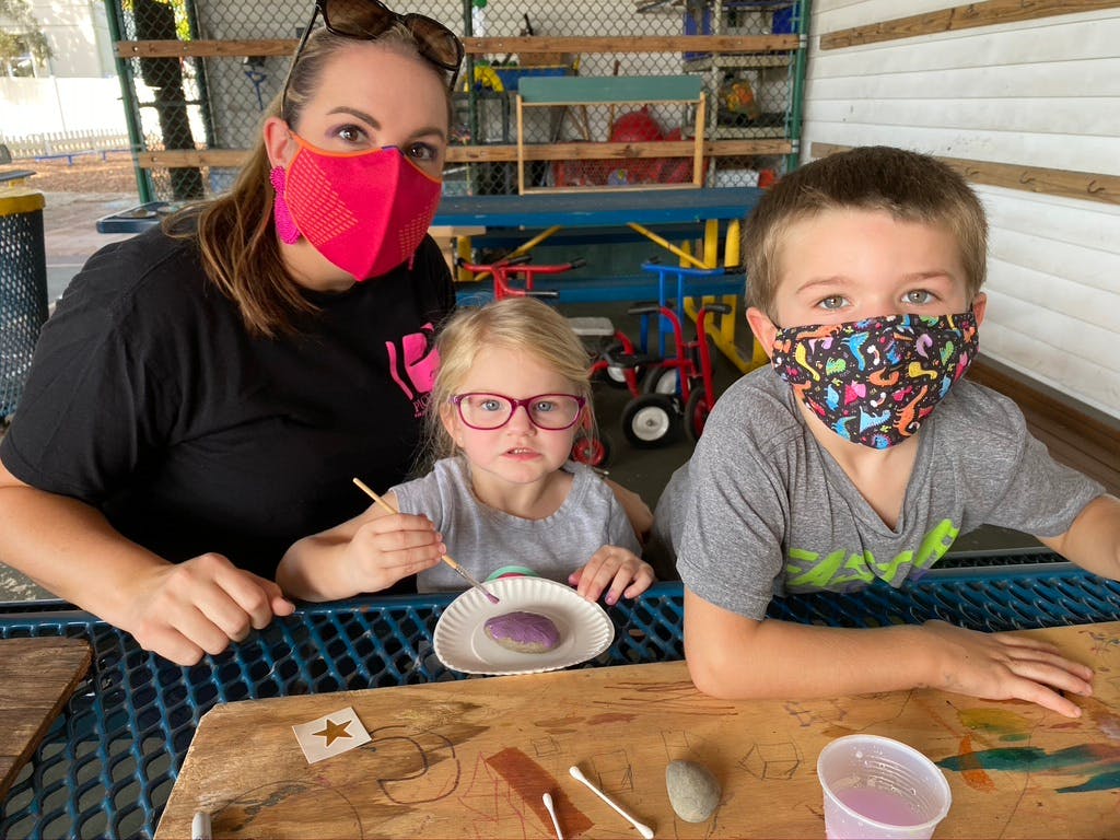 Person and two children wearing masks, painting