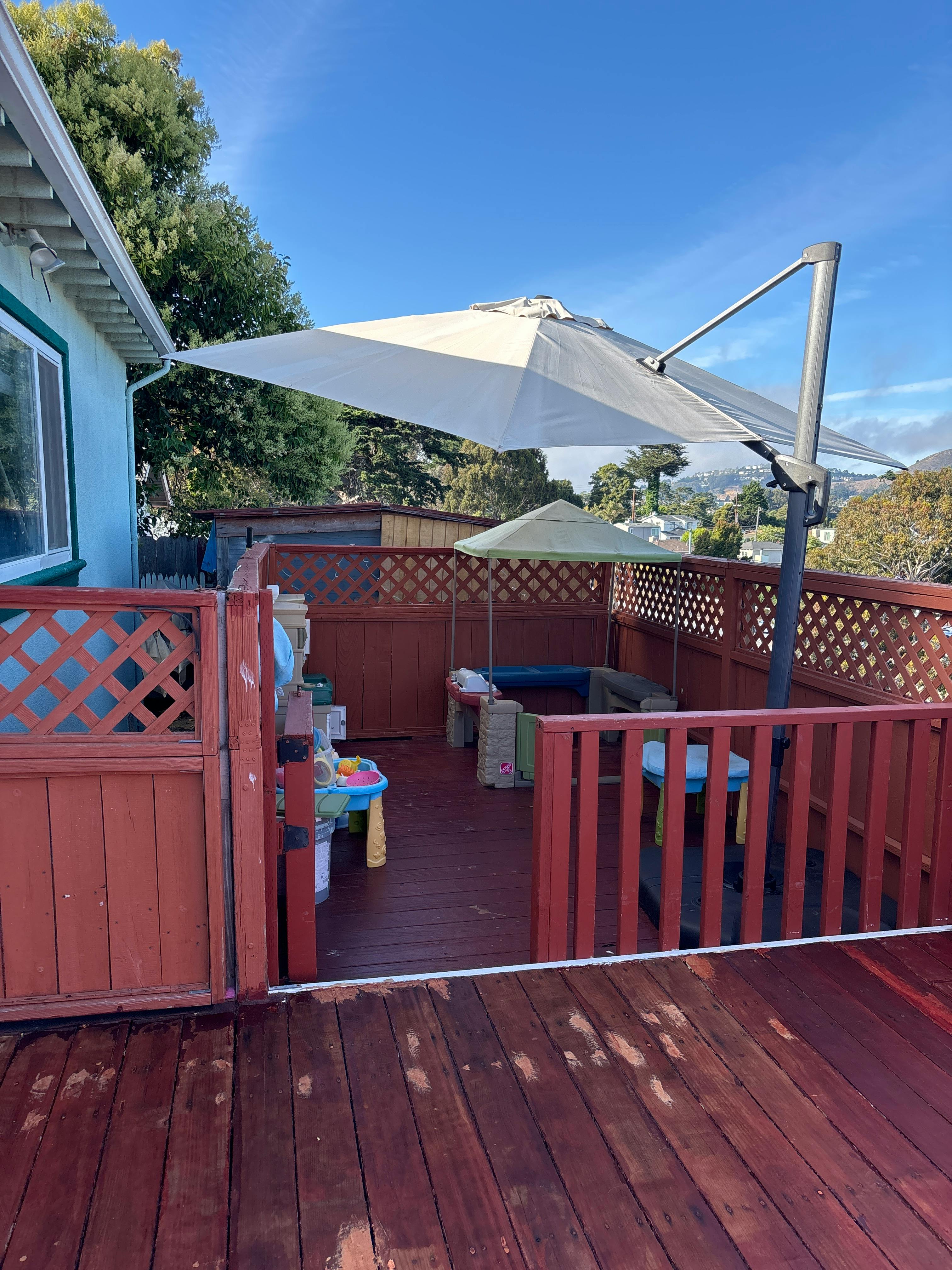 Outdoor deck with a large patio umbrella and a smaller umbrella
