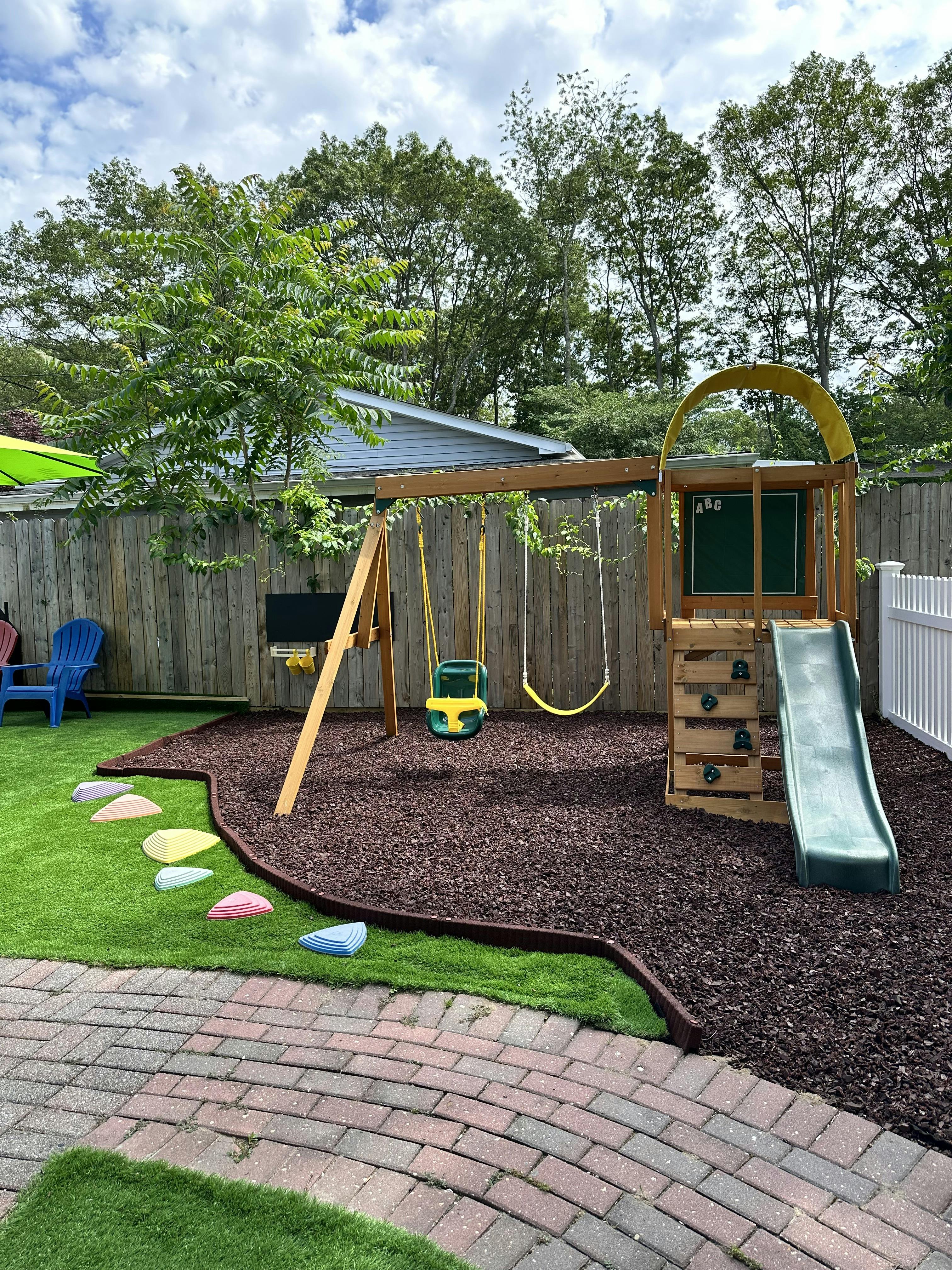 Outdoor playground with swings, slide, and climbing structure