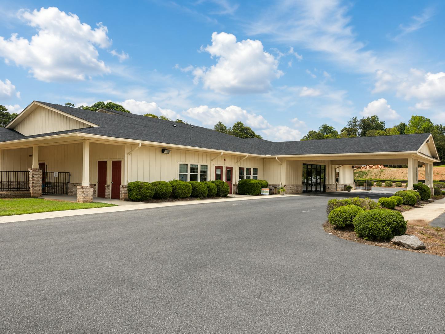 Single-story commercial building with a covered entrance and asphalt driveway