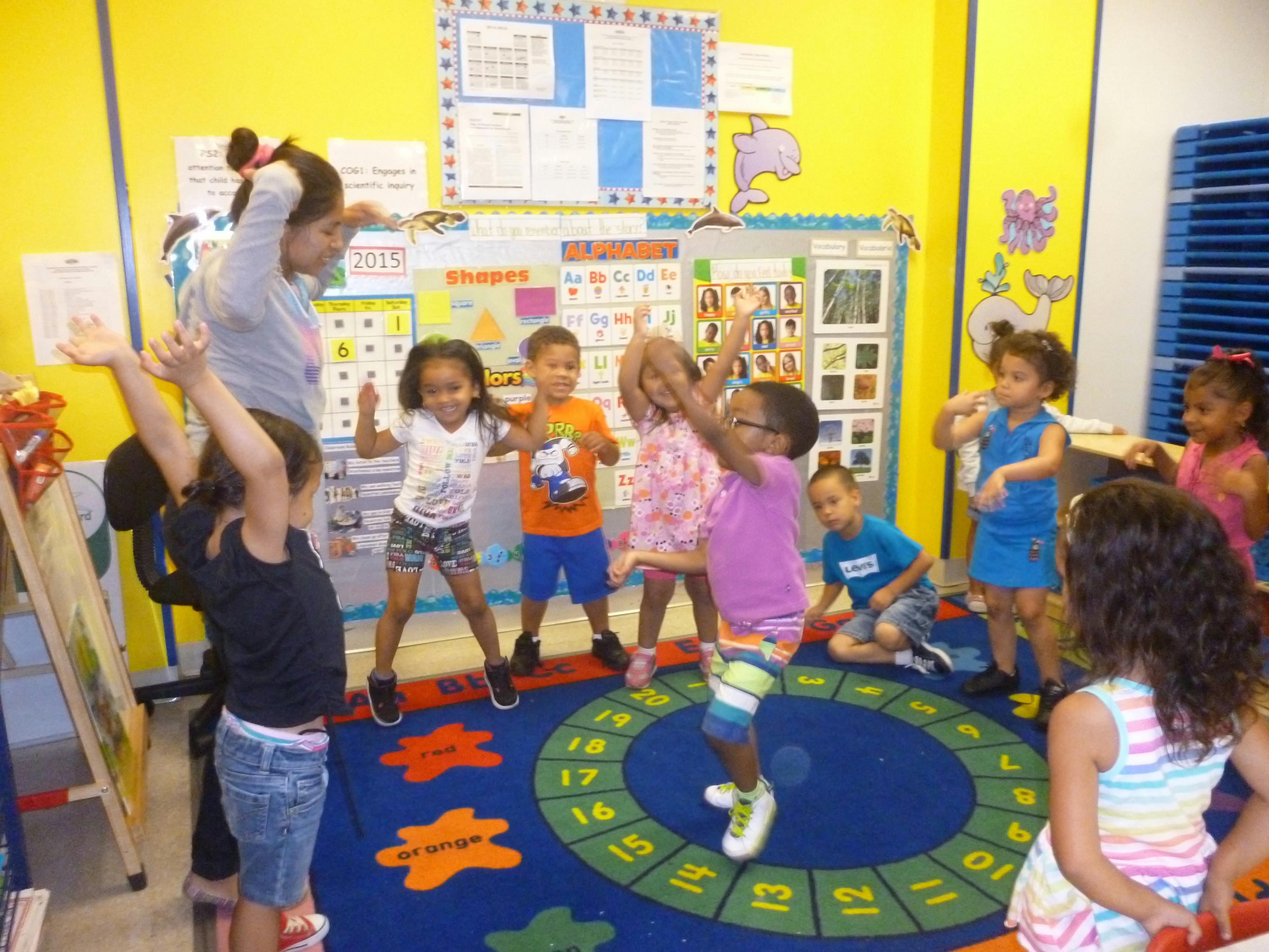 Adult and children dancing in a classroom