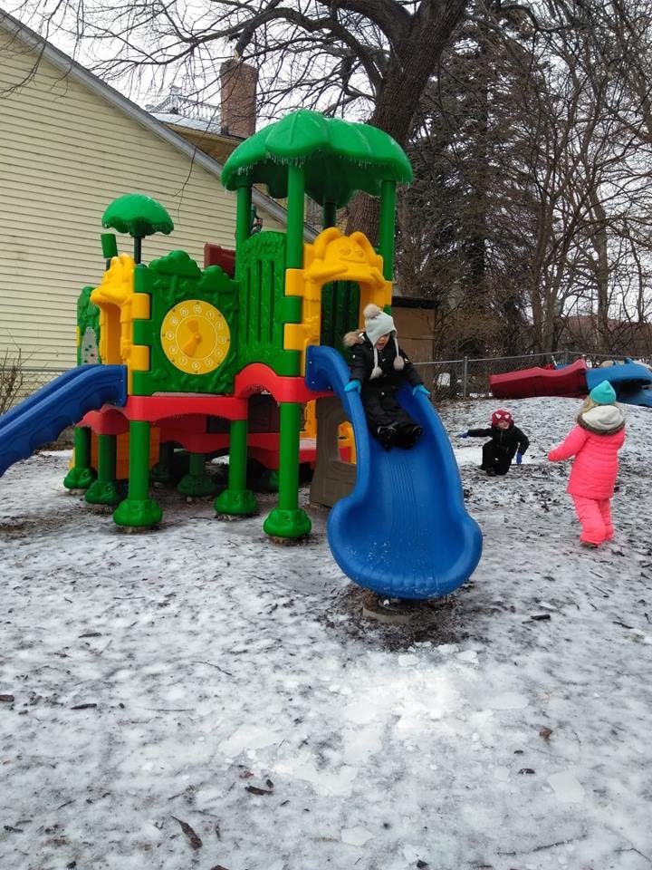 Children playing on a playground slide in the snow
