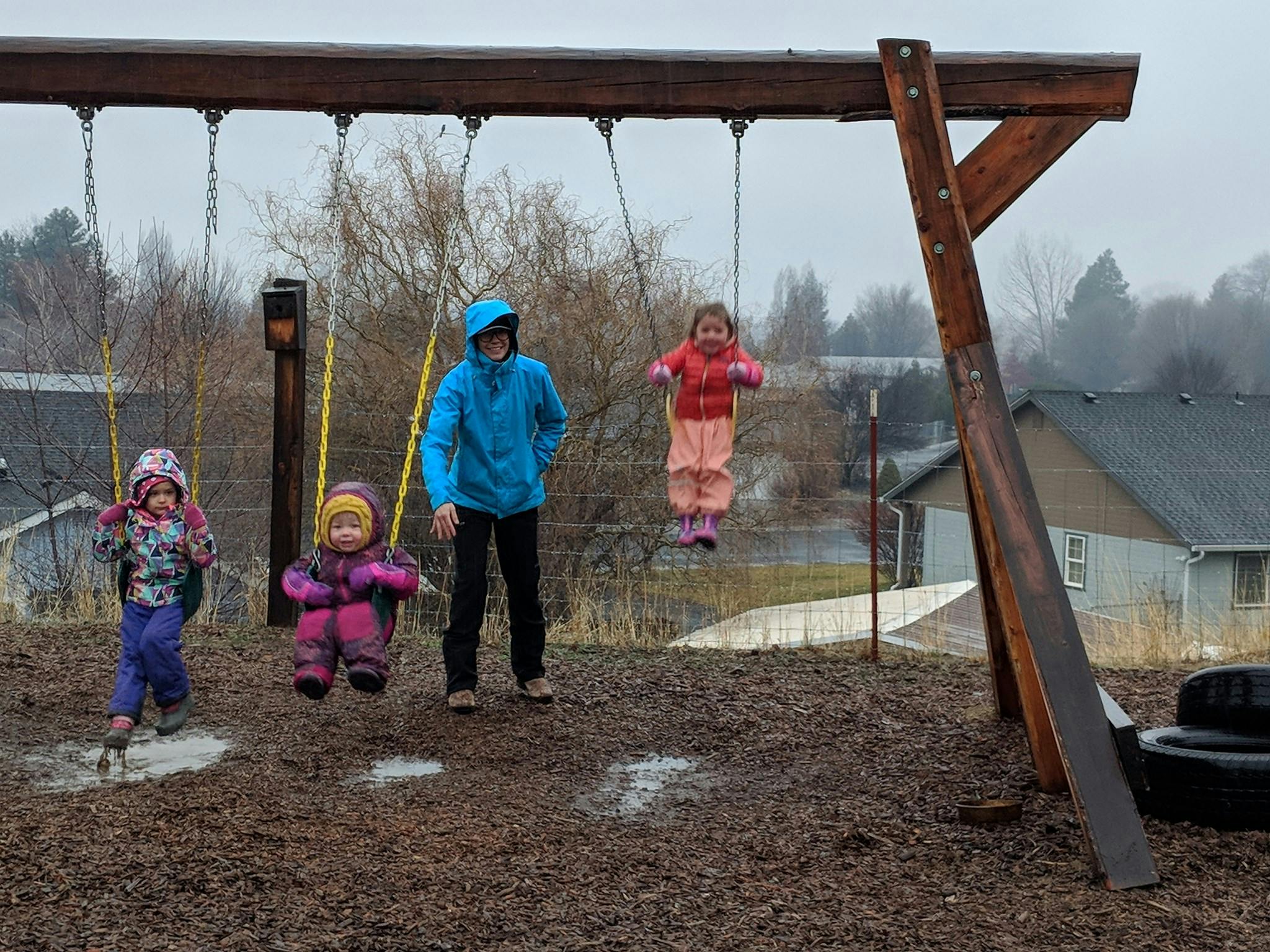 Person standing near children on swings