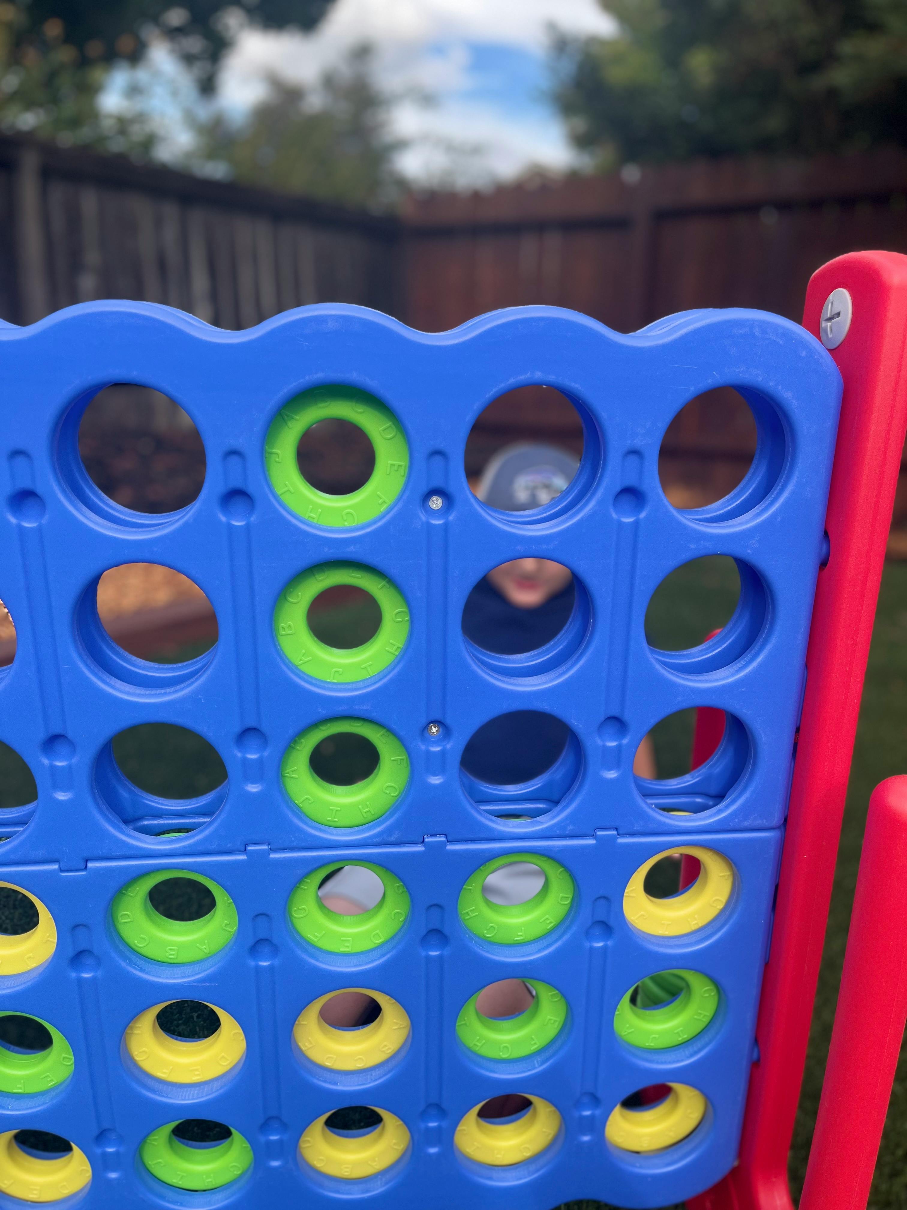 Child playing a large connect four game