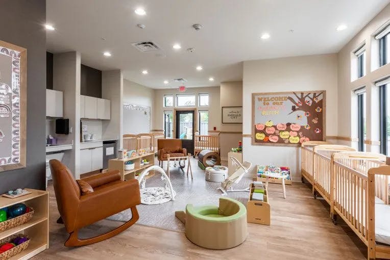 Nursery room with cribs, rocking chair, and play items