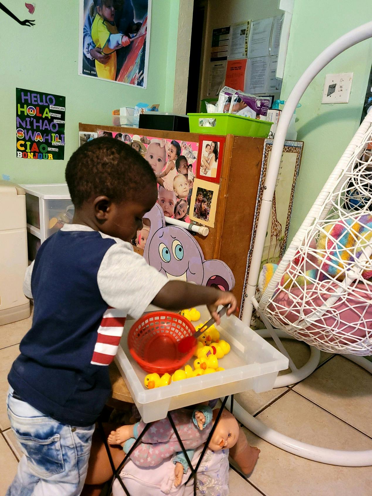 Child playing with rubber ducks and a red basket