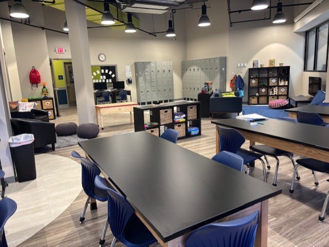 Classroom with tables, chairs, lockers, and storage shelves