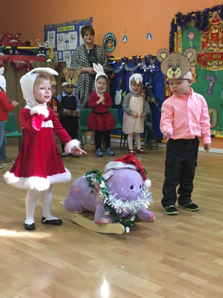 Children in costumes with a teacher in a classroom