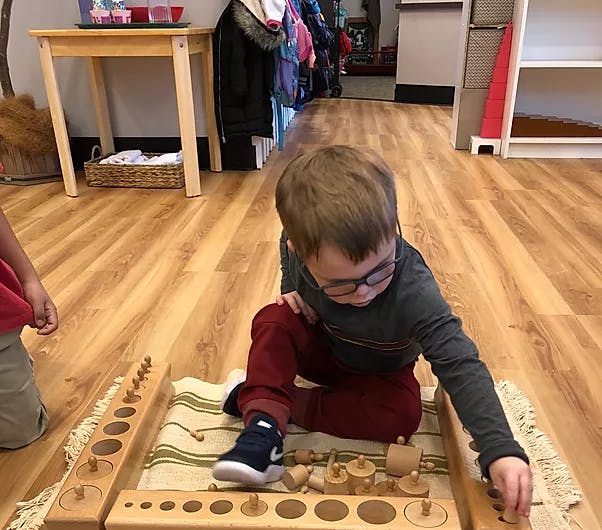 Child playing with wooden puzzle on floor