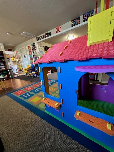 Colorful playhouse in a room with an alphabet rug