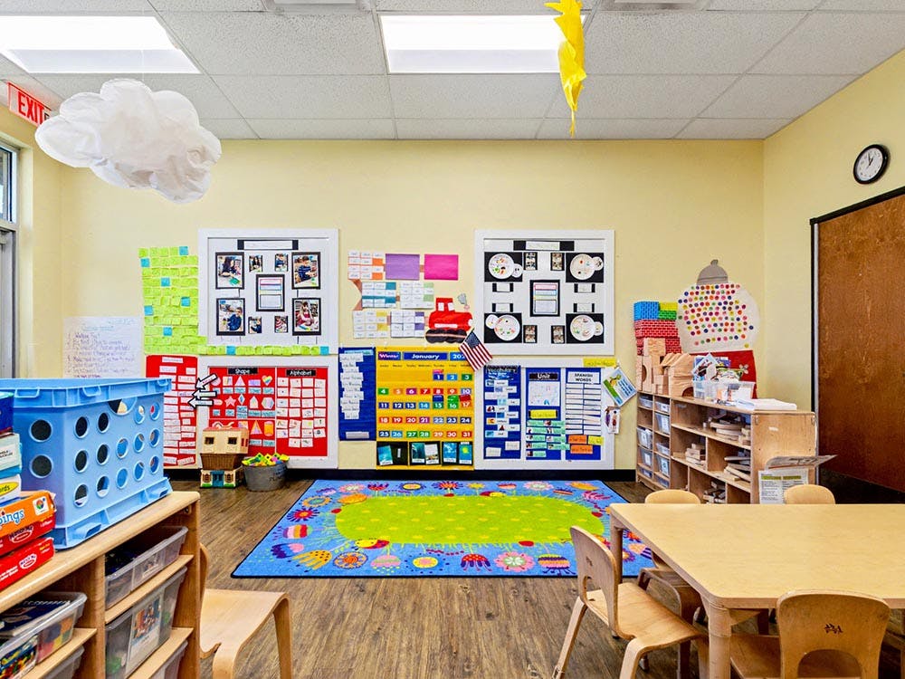 Classroom with child-sized furniture and colorful educational posters on the wall