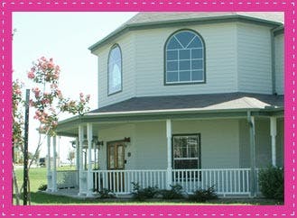 Exterior of a house with a wrap-around porch and arched windows