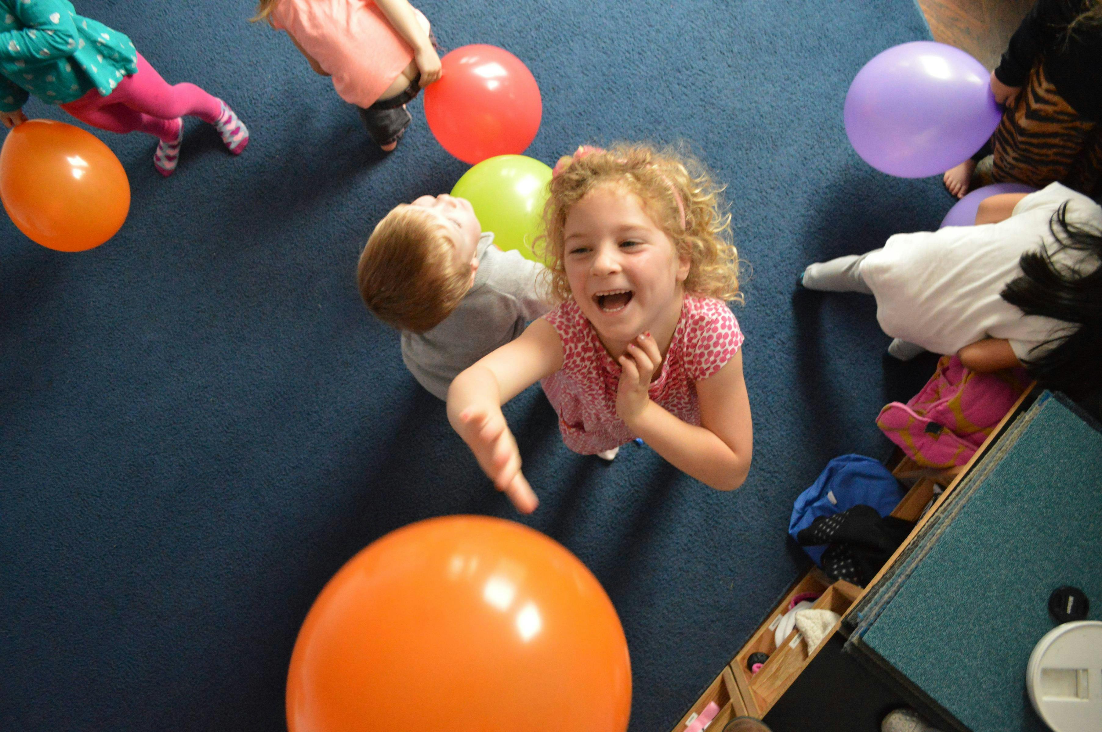 Child playing with balloons on the floor
