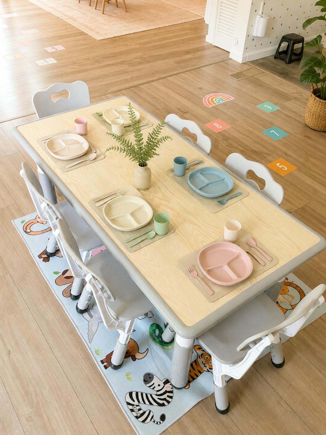 Child-sized table set for four with colorful plates and cups