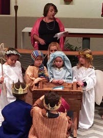 Adult and children in costumes performing a play