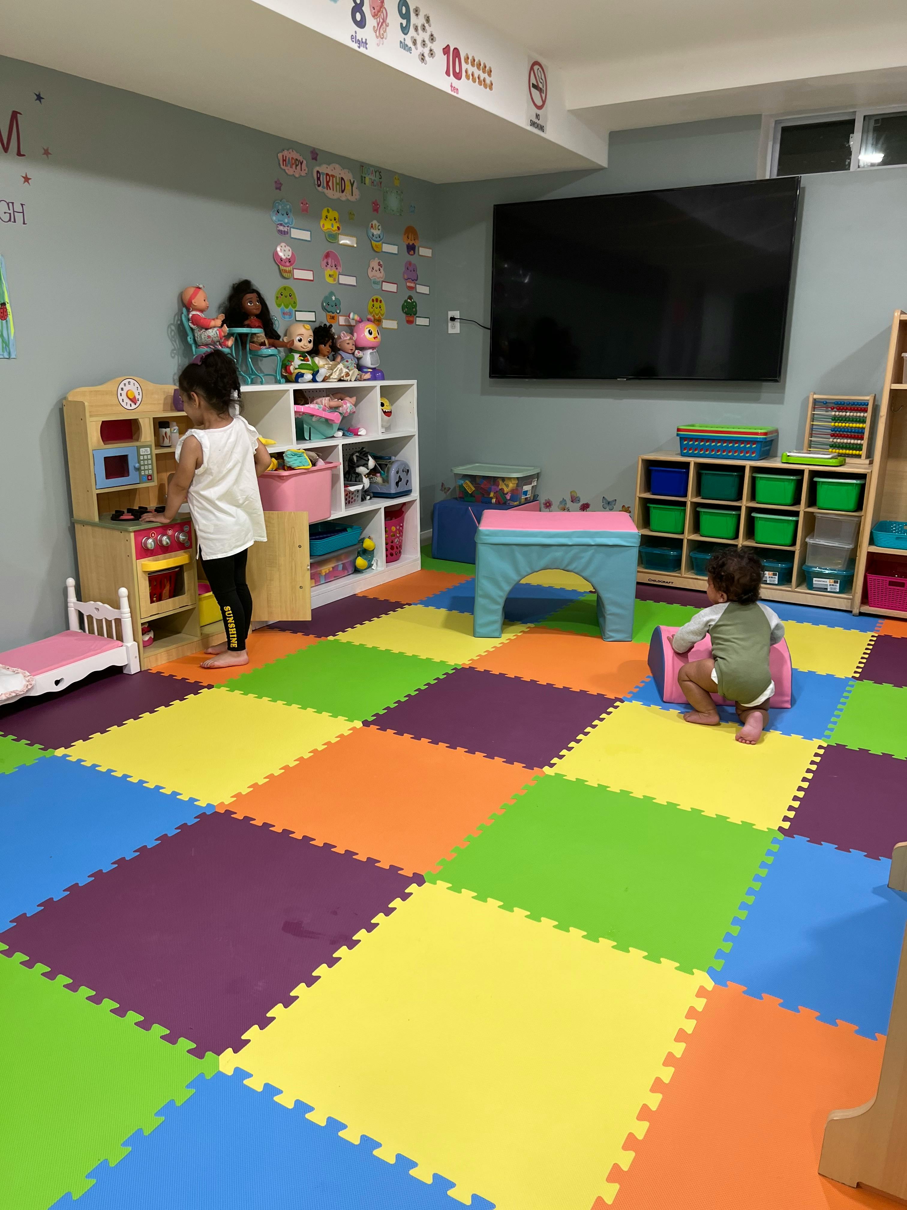 Two children playing in a room with colorful floor mats