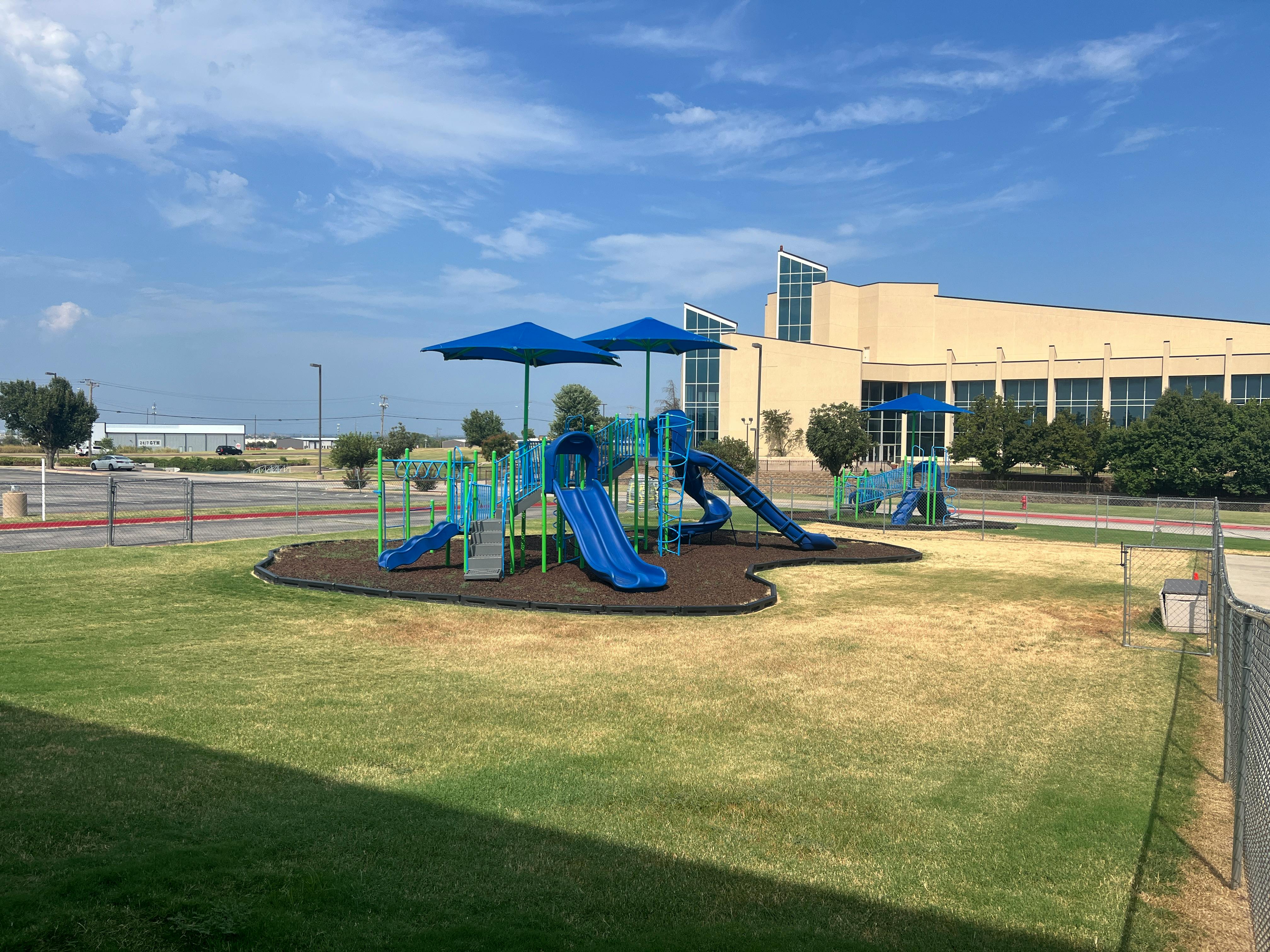 Playground with slides and climbing structures on a grassy area