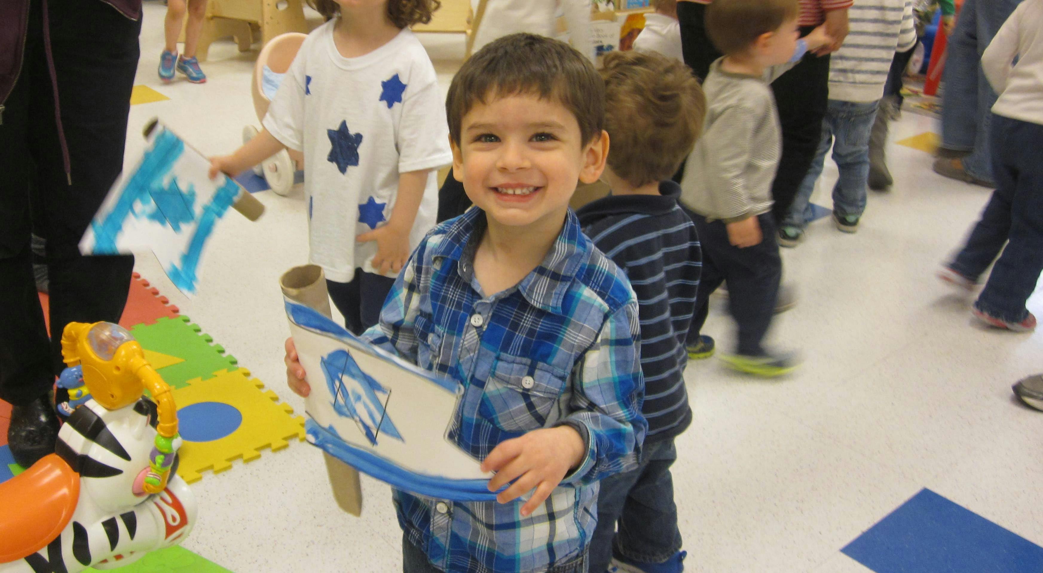 Child holding a small flag with a blue design, abstract design