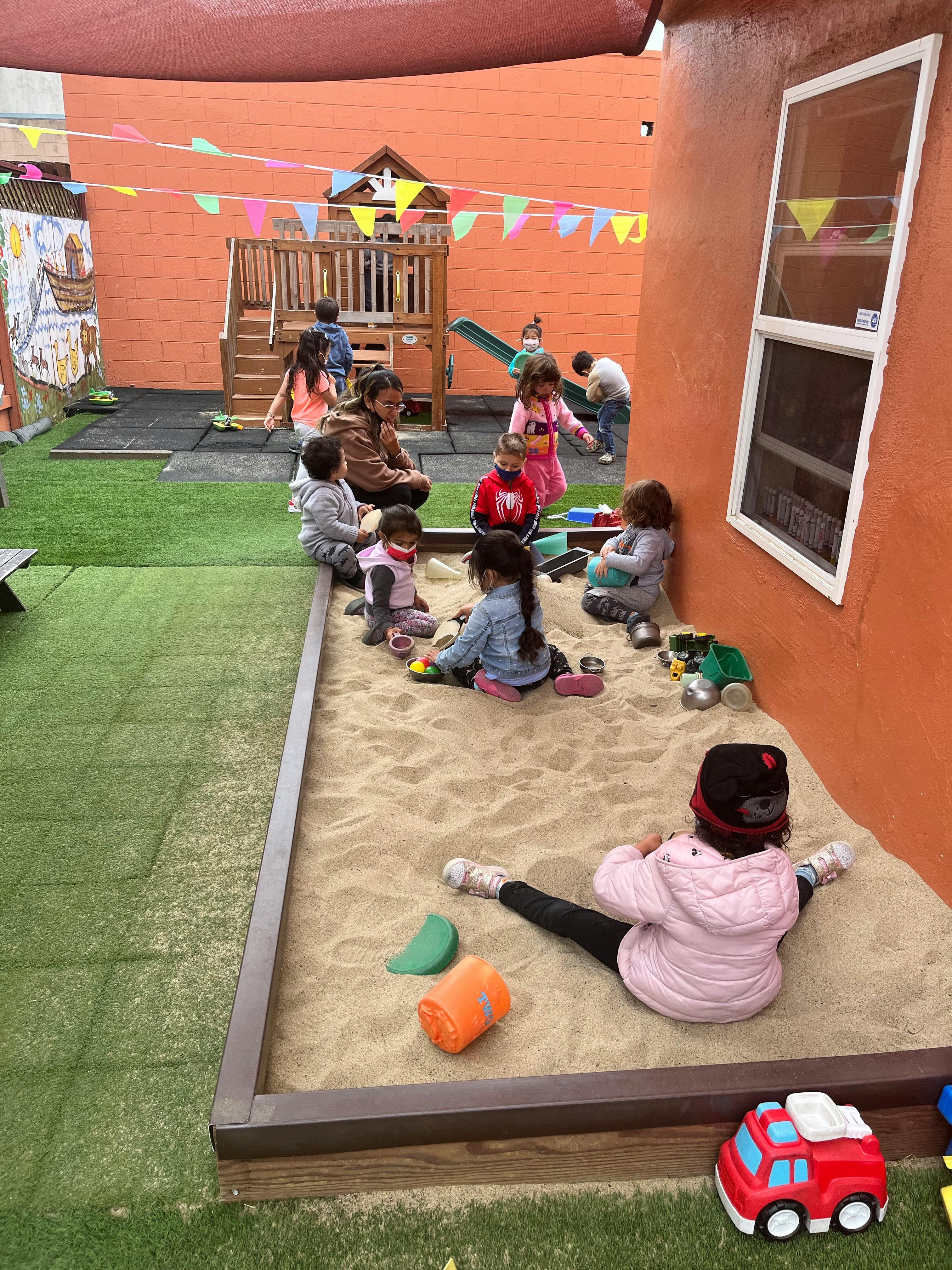 Children playing in a sandbox and on a playground