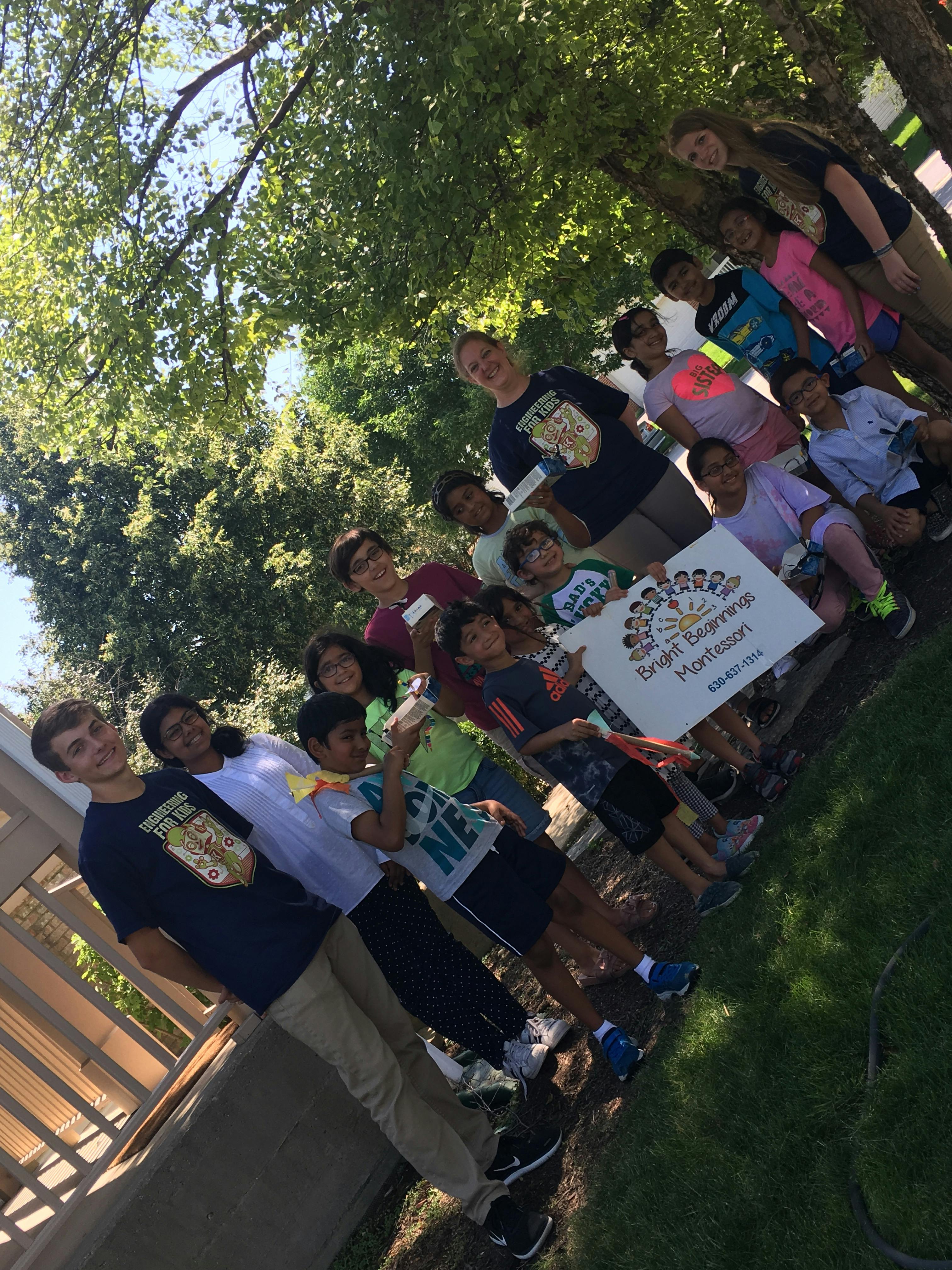 Group of people and children holding a sign outdoors