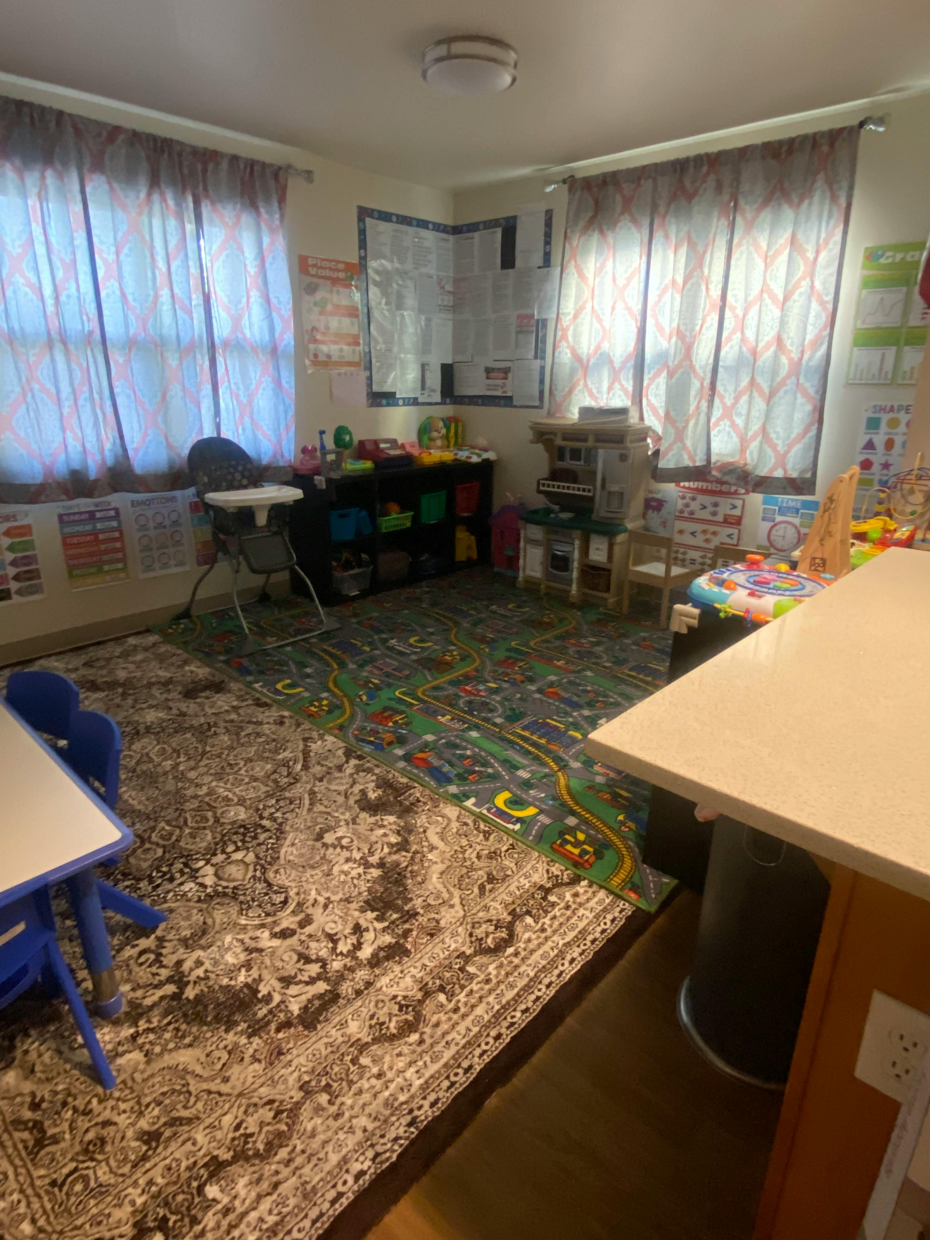 Playroom with two rugs, a high chair, and toys