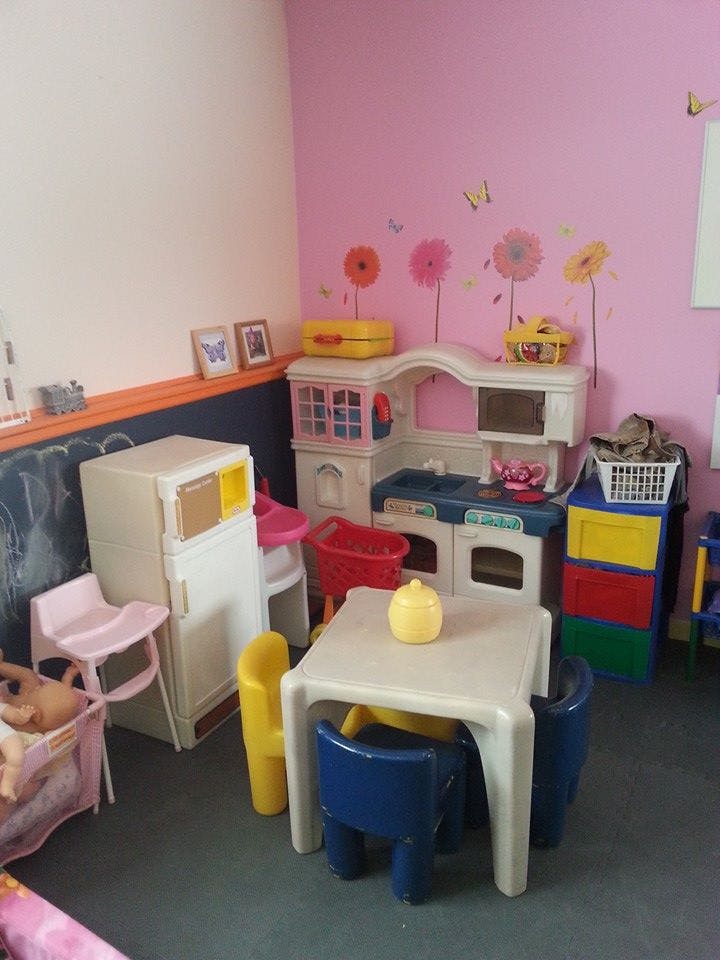 Play kitchen set with a table and chairs in a room