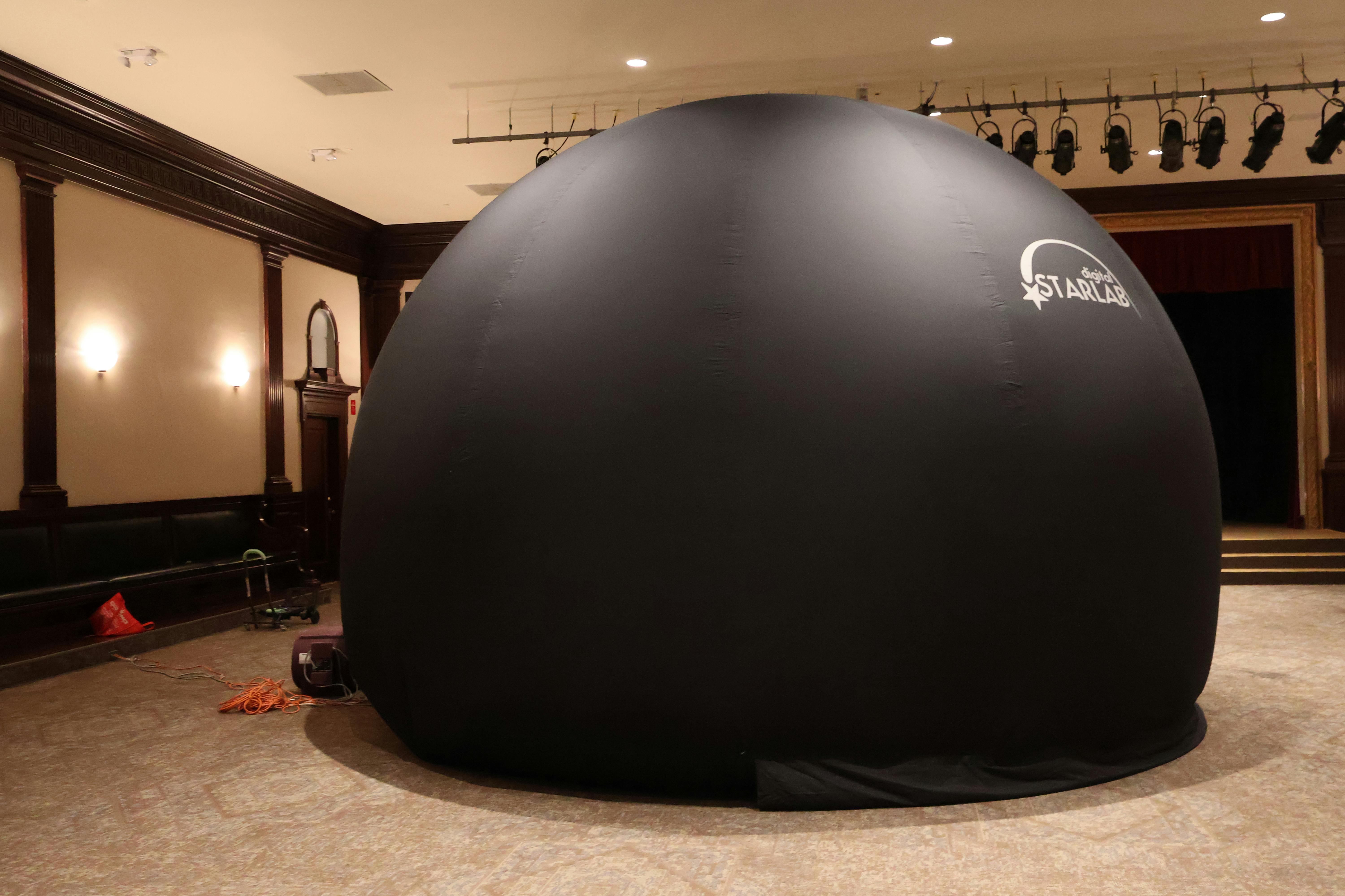 Inflatable black dome with 'Digital StarLAB' logo in a large room
