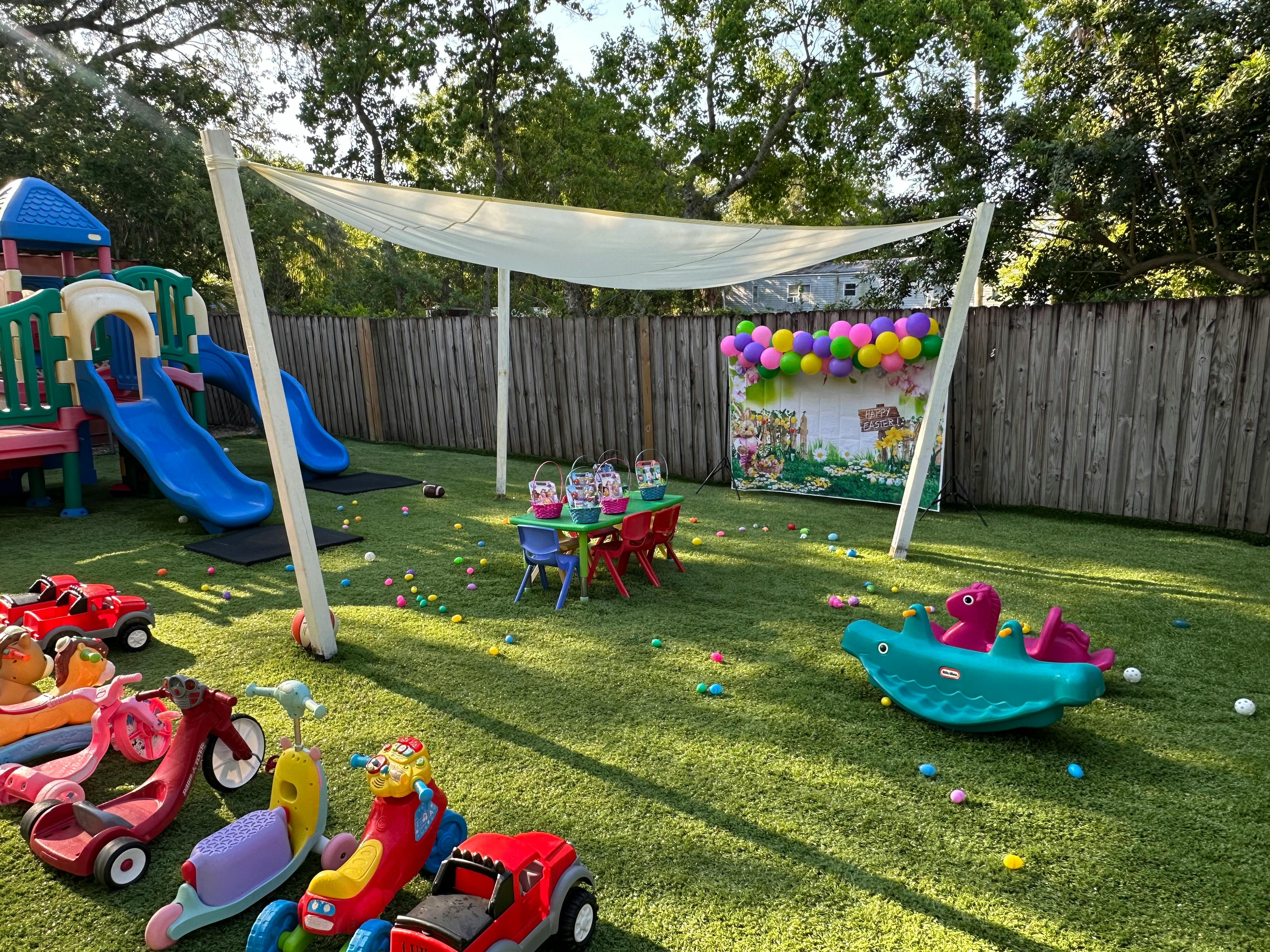 Outdoor play area with slides, small table and chairs, and toys on-ground toys