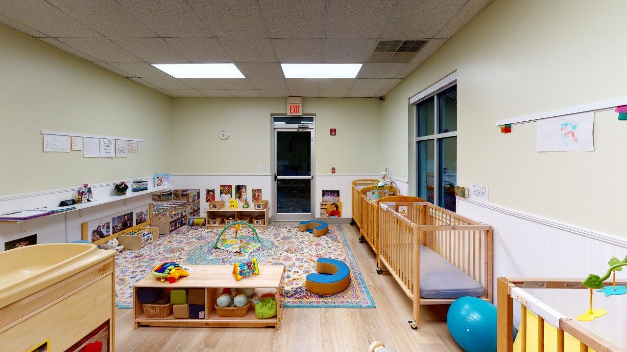 Nursery room with cribs, play mats, and toys