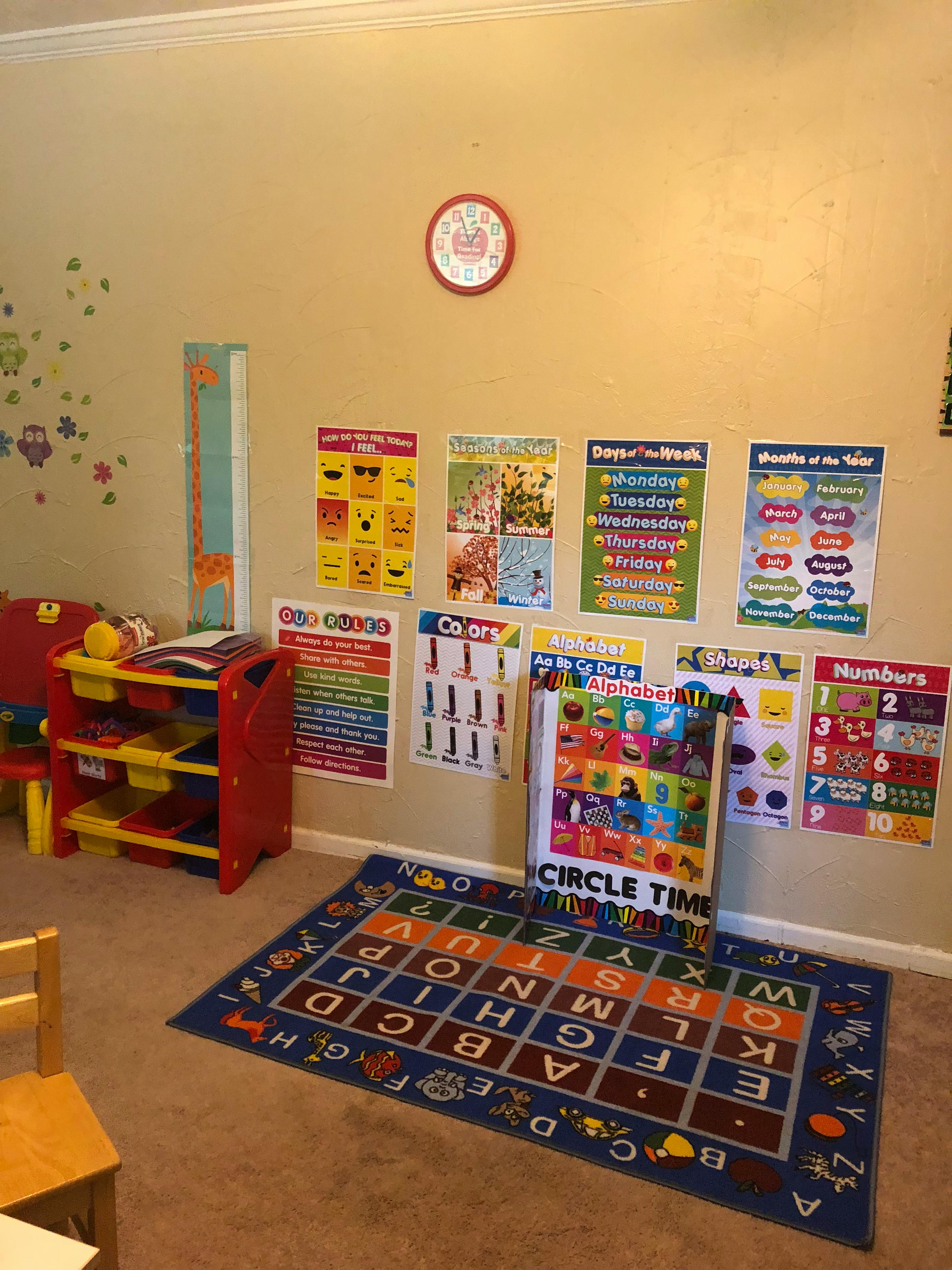 Classroom with educational posters on the wall and an alphabet rug on the floor