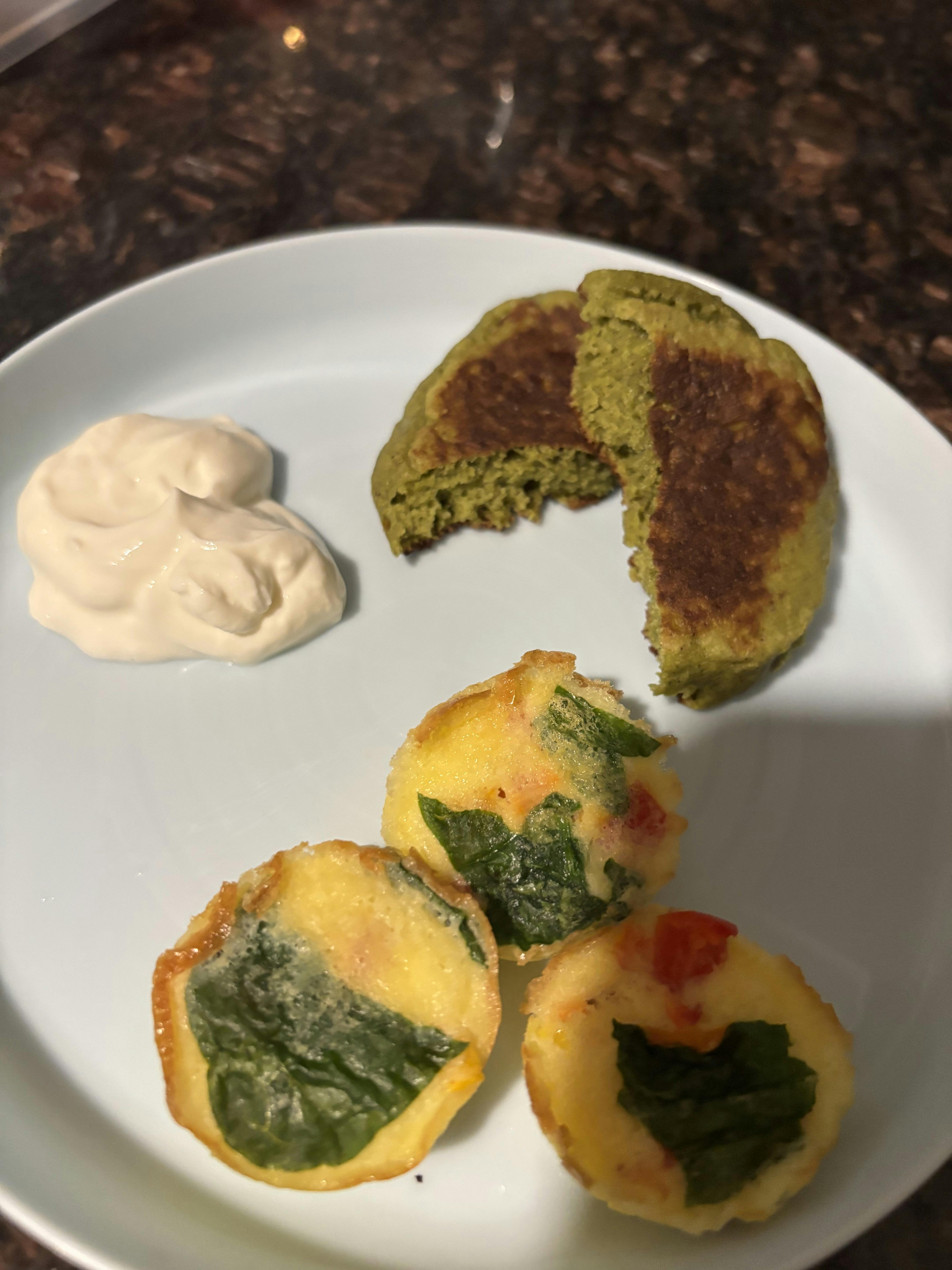 Plate with egg bites, a vegetable patty, and a dollop of cream
