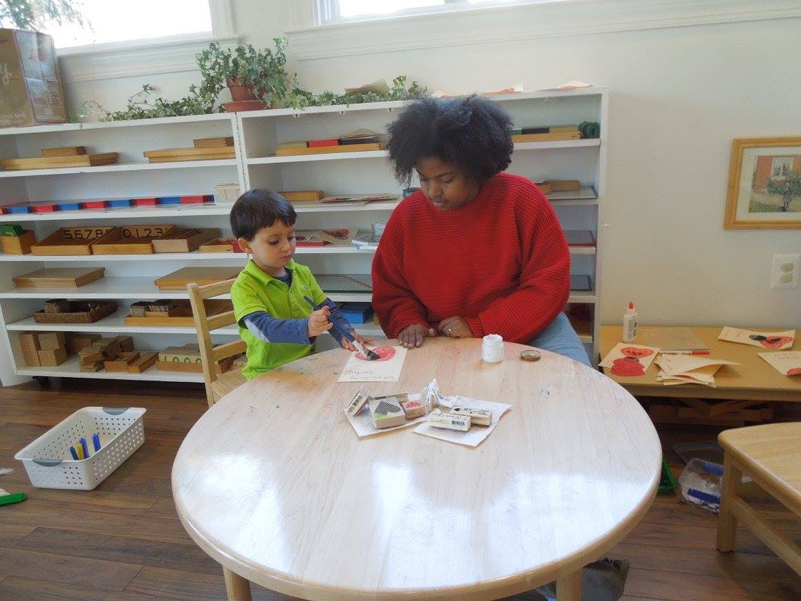Person and child at a table doing an activity