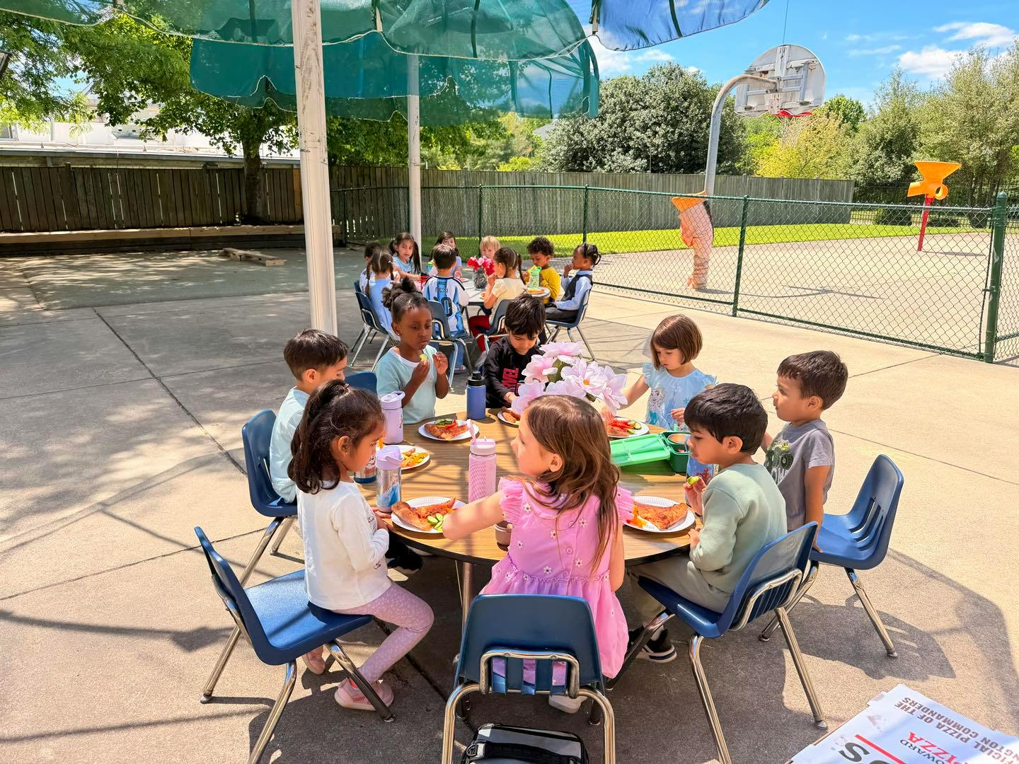 Group of children eating at a table outdoors