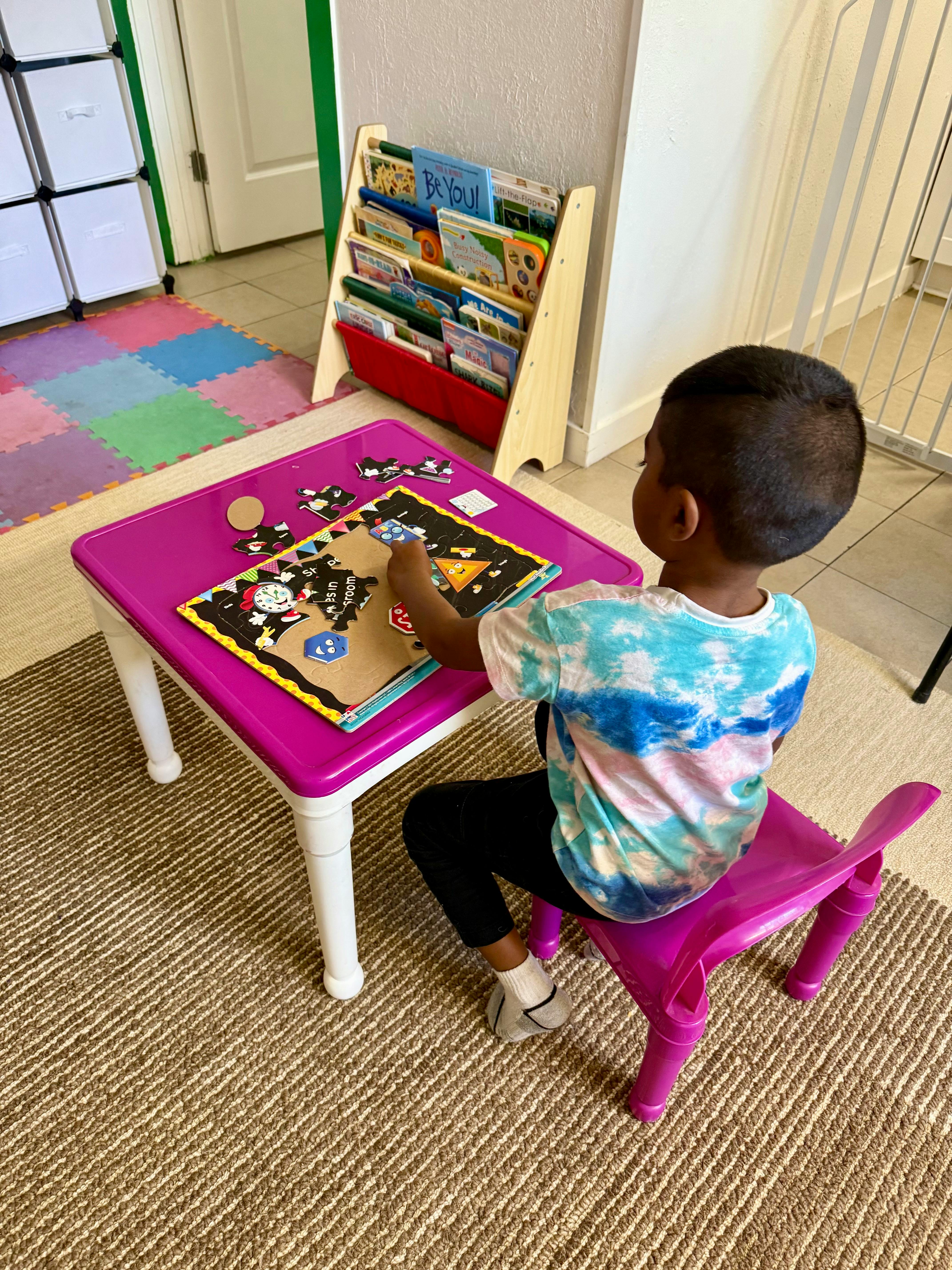 Child playing with a puzzle at a small table
