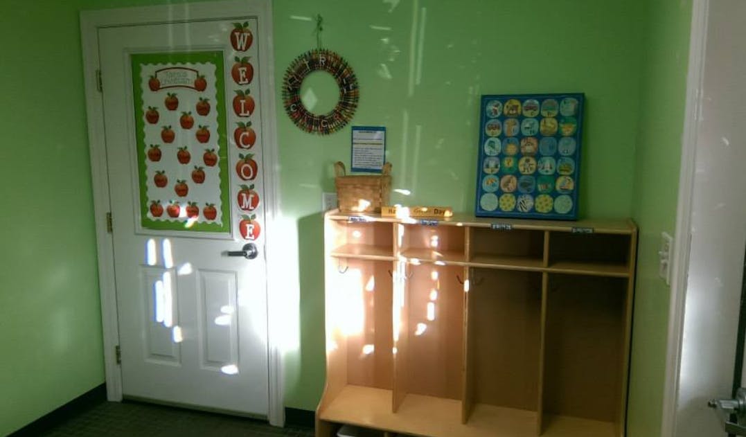 Door with apple decorations next to wooden cubbies