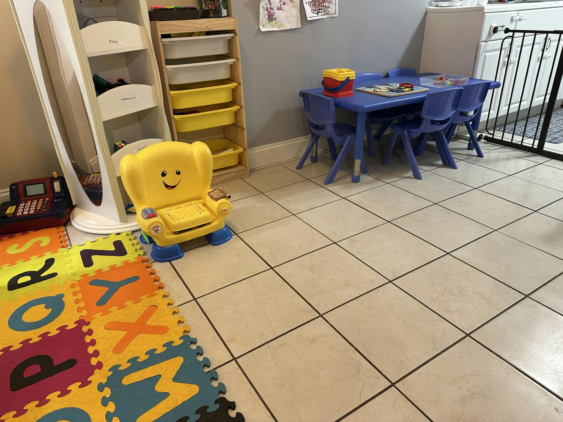 Child's yellow chair with a smiling face on an alphabet mat