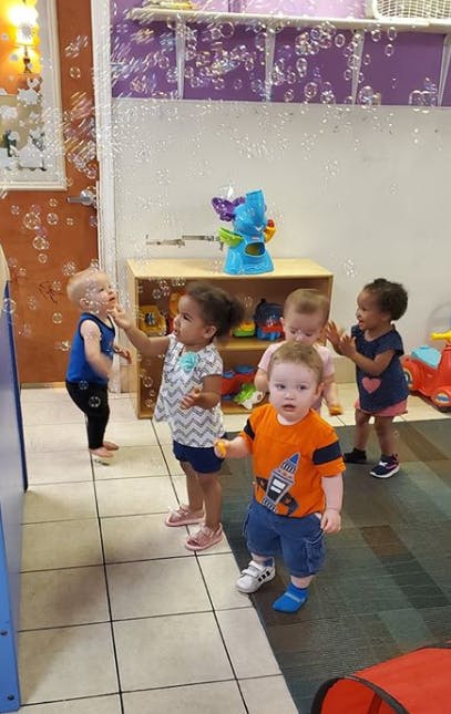 Children playing with bubbles in a room