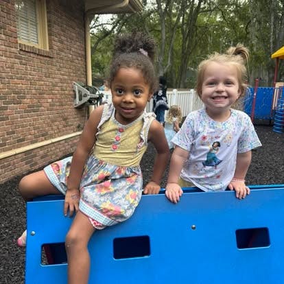 Two children on a blue play structure