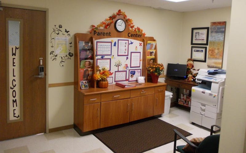A Parent Center display cabinet with brochures and information, next to a welcome sign on a door