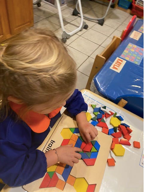 Child playing with colorful geometric shape puzzle pieces