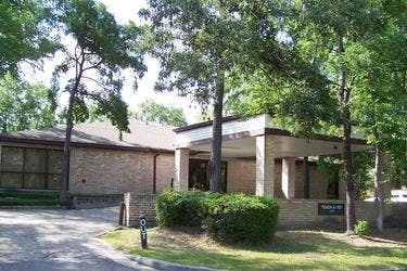 Brick building with an overhang entrance and surrounding trees