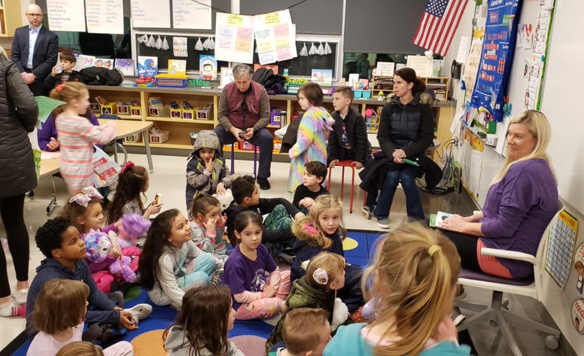 Adults and children gathered in a classroom