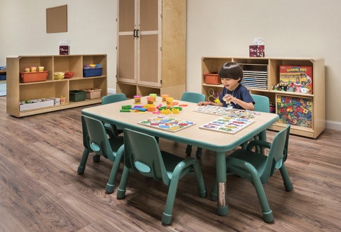 Child playing with toys at a table in a classroom