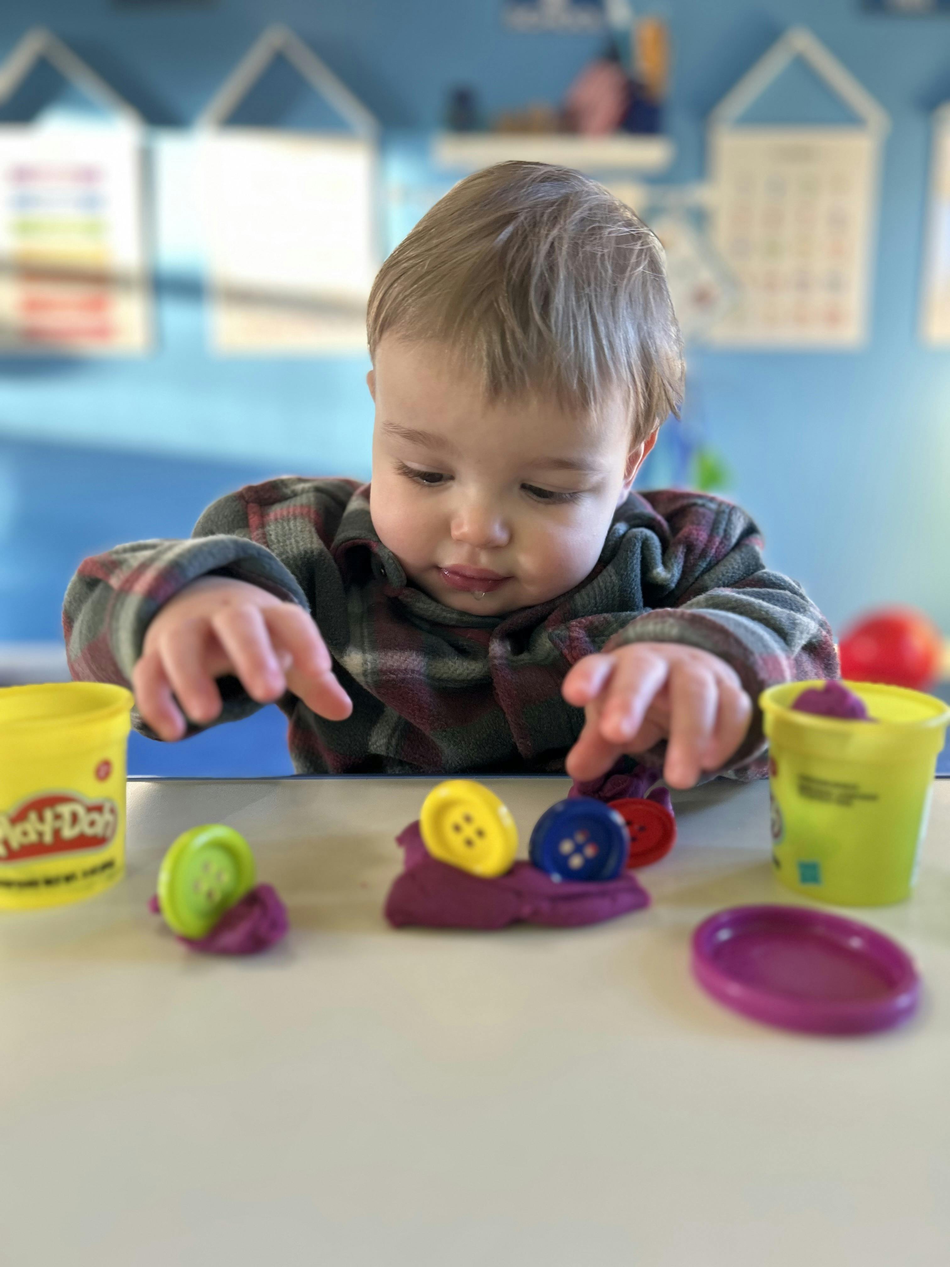 Child playing with Play-Doh and buttons